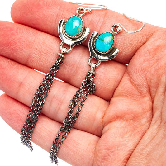 Turquoise drop earrings with oval stones, crescent silver caps, and chain tassels