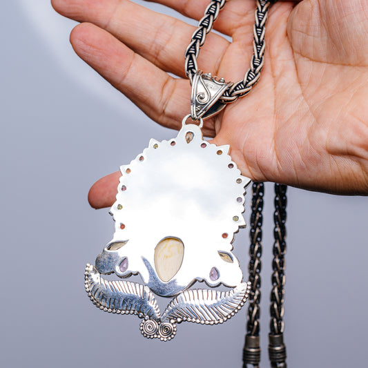 Sterling silver necklace with white oval pendant, purple stones, and beaded trim