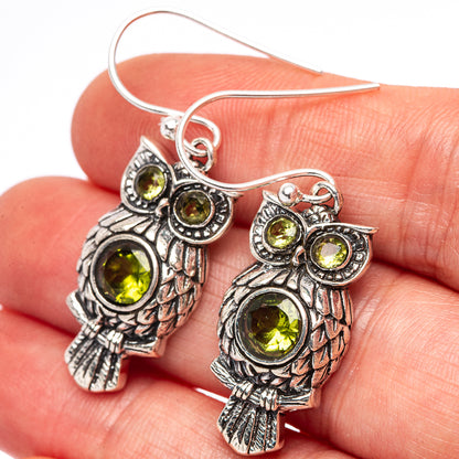 Sterling silver owl earrings with round peridot-green gemstone eyes and details