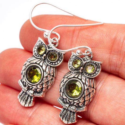 Sterling silver owl earrings with round peridot-green gemstone eyes and details