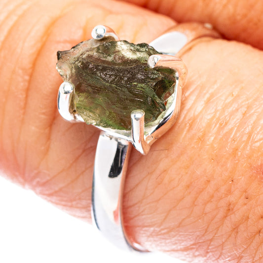 Sterling silver ring with rough green moldavite stone in an open bezel setting