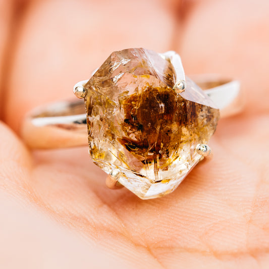 Quartz ring with a faceted brown-included stone in a sterling silver setting