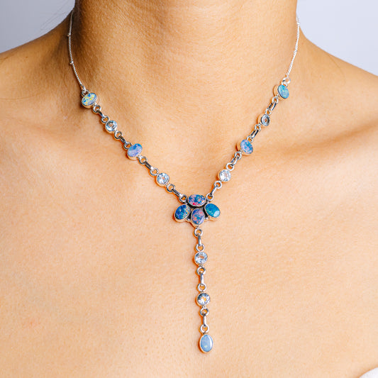 Sterling silver necklace with blue opal-style stones and dangling oval charm