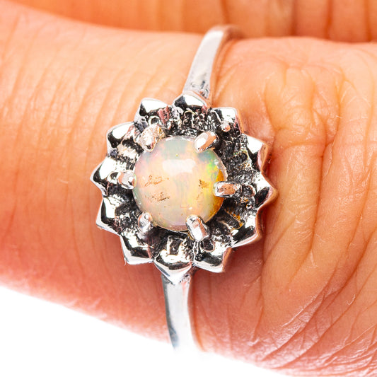 .925 sterling silver opal flower ring with dark prong accents, viewed on hand