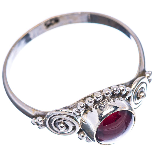 Sterling silver garnet ring with round dark red gemstone and swirl prongs