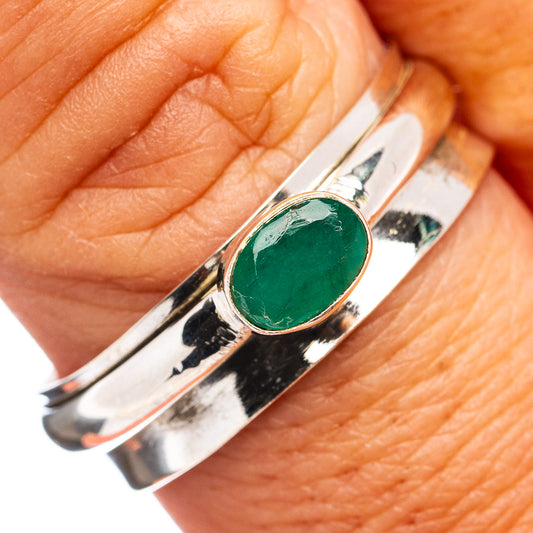 Sterling silver spinner ring with oval green gemstone cabochon, polished band.