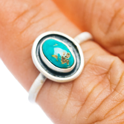 Oval turquoise cabochon ring in sterling silver with black bezel and gold-toned matrix