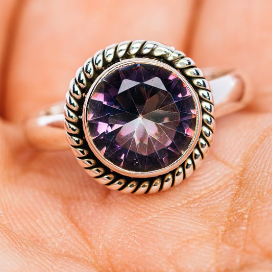 Close view of round purple gemstone ring with textured sterling silver band