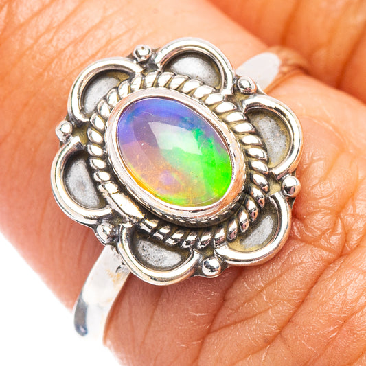 Sterling silver oval opal ring on finger, bright rainbow iridescent center stone