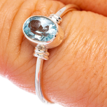 Sterling silver dainty ring with oval blue topaz gemstone, side knot setting