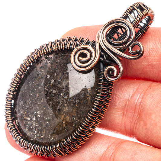 Oxidized copper wire-wrapped sunstone teardrop pendant with coiled bezel and scroll loops