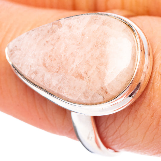Oval rose quartz bezel ring with .925 sterling silver band, worn on finger
