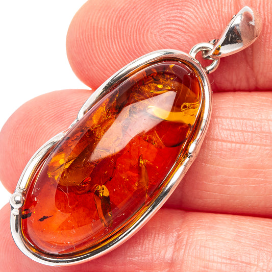 Oval amber pendant in .925 sterling silver bezel with faceted amber stone detail