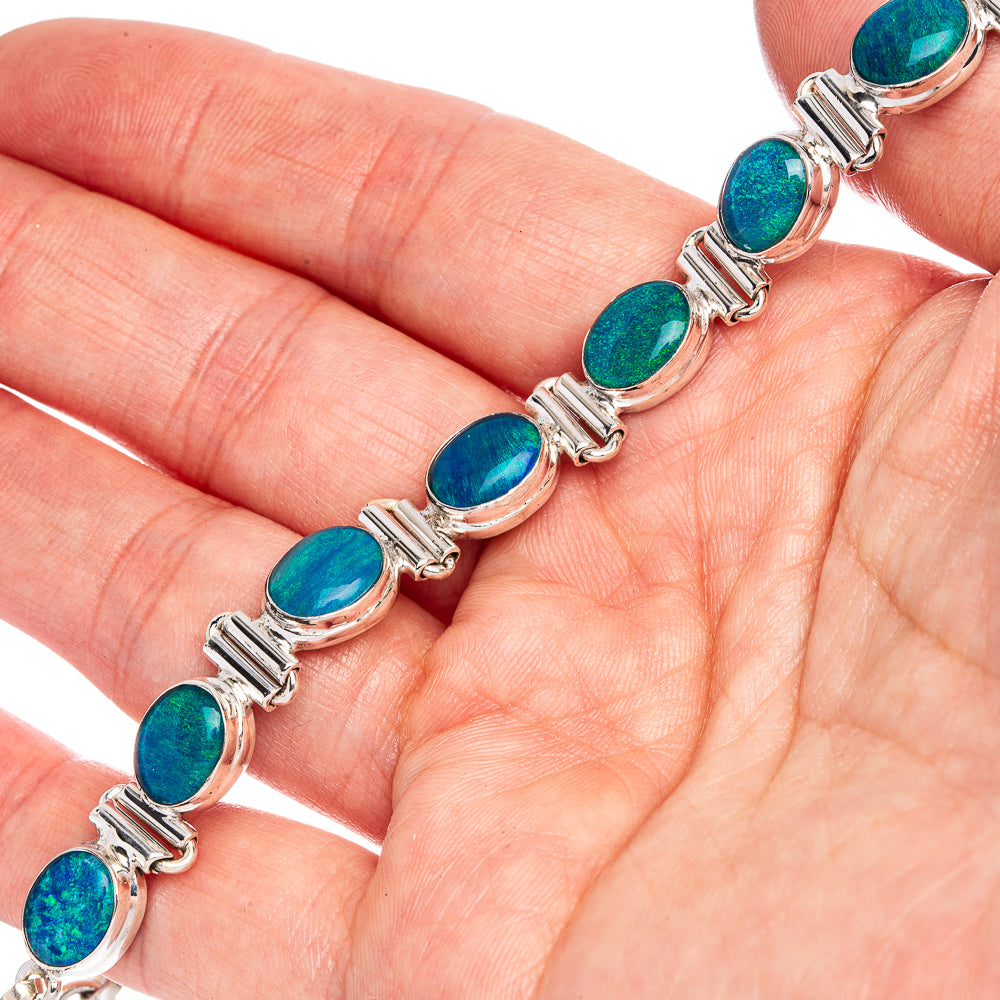 Sterling silver opal bracelet on hand, close-up of blue oval doublet stones and bars