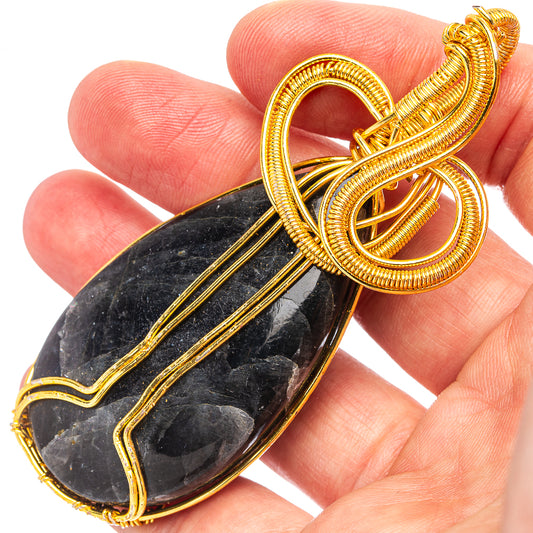 Gold-plated wire wrap pendant with dark oval larvikite cabochon and looped wire frame