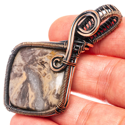 Oxidized copper wire-wrapped pendant with oval fossil stone and loop bail