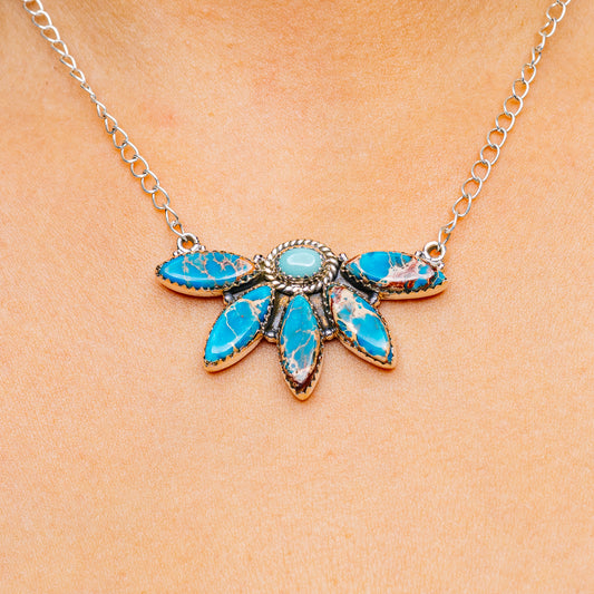 Turquoise gemstone pendant necklace with silver chain and leaf-shaped stone cluster center