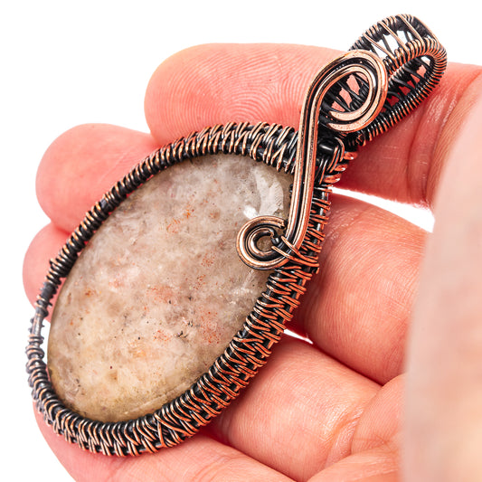 Oxidized copper wire-wrapped pendant with oval stone center and looped bail