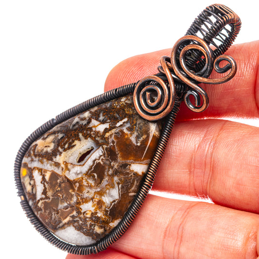 Oxidized copper wire-wrapped tube agate pendant with swirling spiral wraps and teardrop stone