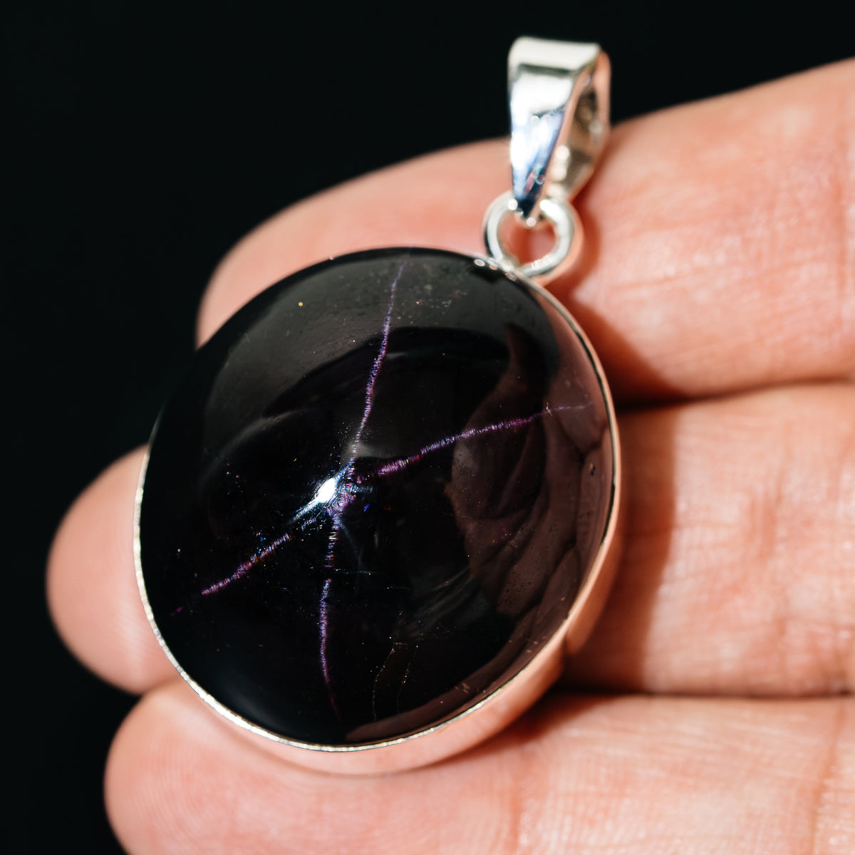 Oval black star garnet pendant in sterling silver bezel with loop bail