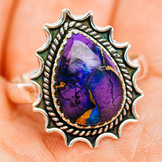 Sterling silver ring with oval purple-blue stone and textured sunburst surround