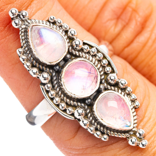 Sterling silver ring with three oval pink opal-like stones and beaded halo setting
