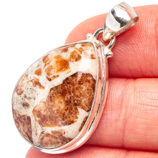 Close-up pear-shaped garnet pendant with sterling silver bail and bezel