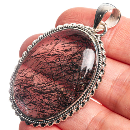 Oval sterling silver pendant with dark red tourmalinated quartz cabochon and loop bail