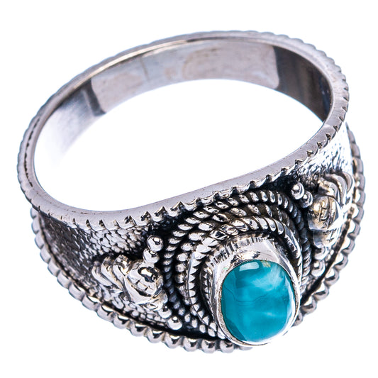 Sterling silver cocktail ring with ornate texture and oval blue gemstone cabochon