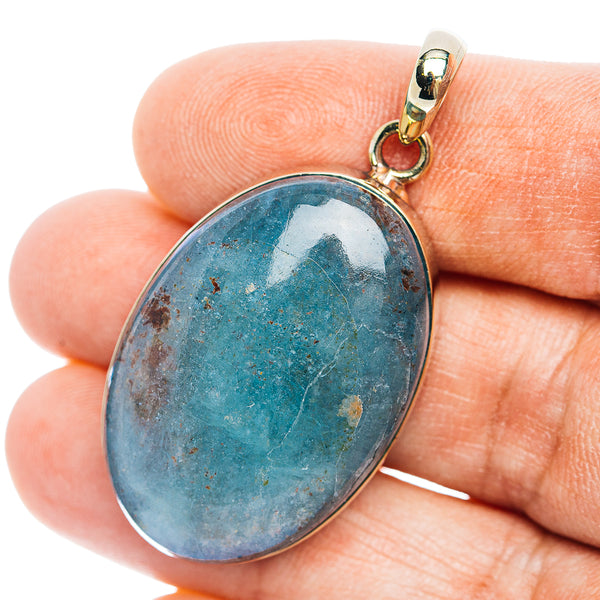 Oval blue stone pendant with gold-tone bail and loop for chain