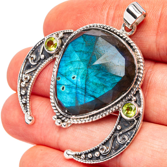 Oval blue labradorite pendant close-up with green peridot stones and silver bail