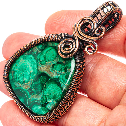 Malachite wire-wrap pendant with oxidized copper spirals, green teardrop stone.