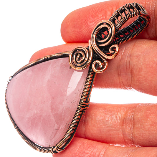 Oxidized copper wire-wrapped rose quartz teardrop pendant with spiral coil details