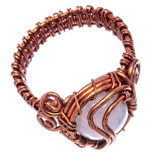 Oxidized copper wire-wrap ring with pale oval moonstone and curled metal loops