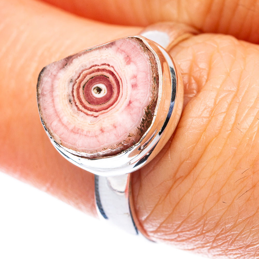 Sterling silver rhodochrosite stalactite ring on hand, oval pink stone with bands