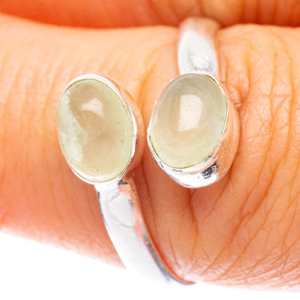 Sterling silver ring close-up with two oval green prehnite stones on prongs