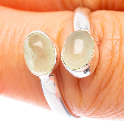 Sterling silver ring close-up with two oval green prehnite stones on prongs