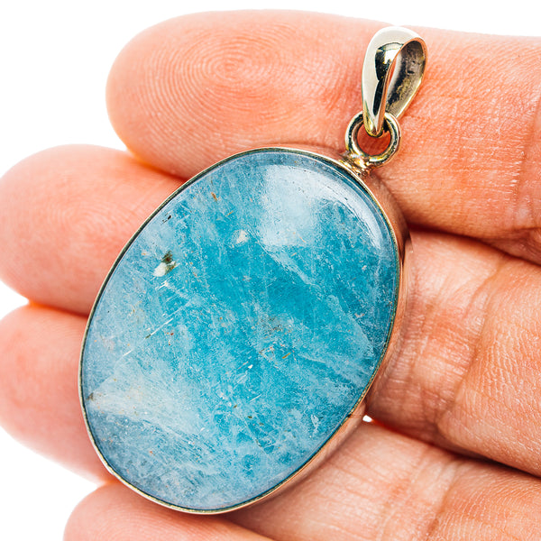 Aquamarine gemstone pendant with oval blue cabochon and gold-tone bail
