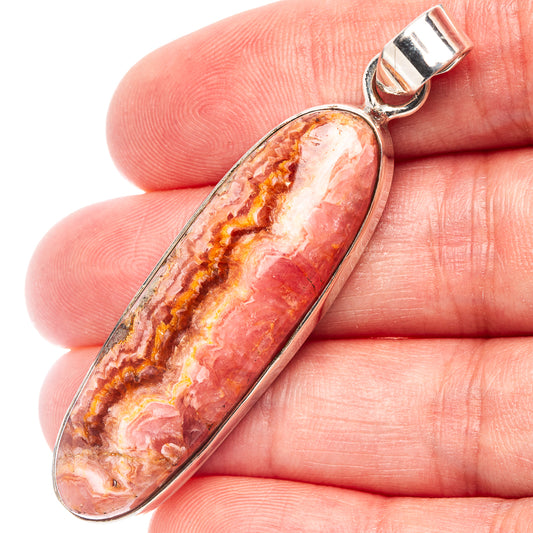 Oval red-and-white rhodochrosite pendant bezel with sterling silver bail on top.