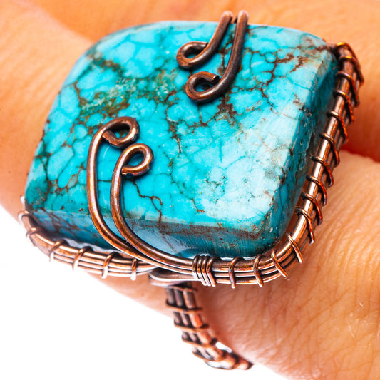 Turquoise oval cabochon oxidized copper wire ring with curled top and linked band.