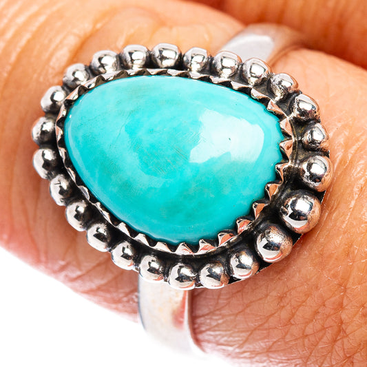 Turquoise teardrop ring in sterling silver with bead bezel, close-up on finger