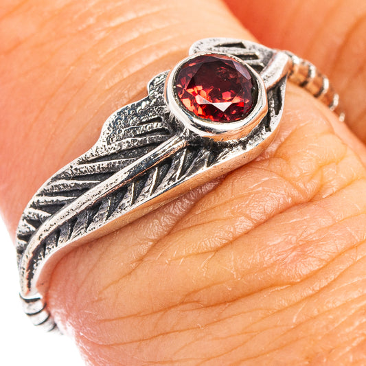 Sterling silver leaf ring featuring round dark red stone in ornate bezel