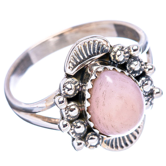 Silver ring with oval pink gemstone, scalloped side details and small bead accents