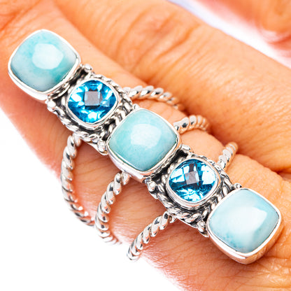 Sterling silver ring on finger with five oval larimar and blue topaz stones