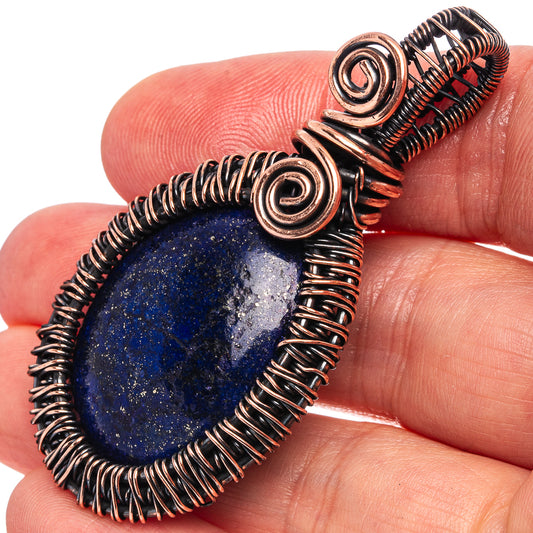 Oxidized copper wire-wrap pendant with dark blue lapis oval stone and spiral coils