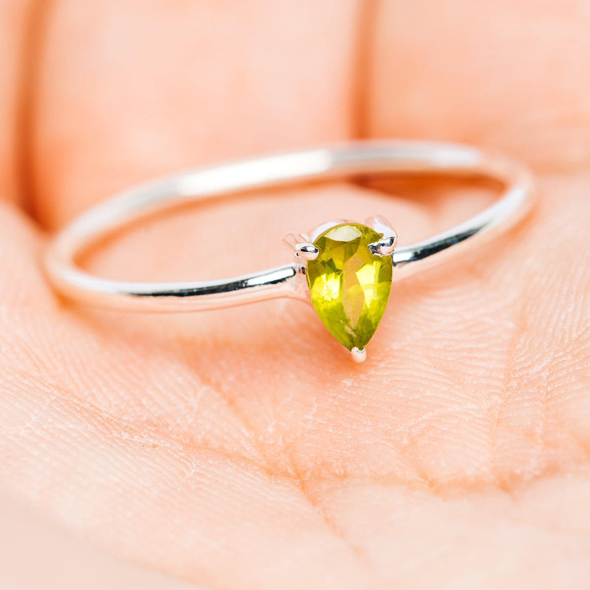 Sterling silver stackable ring showing pear-cut green peridot on top