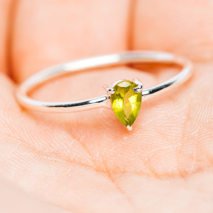 Sterling silver stackable ring showing pear-cut green peridot on top
