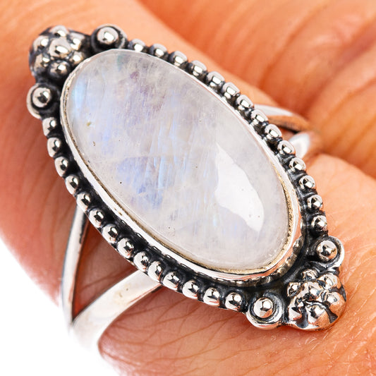 Oval moonstone ring on finger, .925 sterling silver with blackened beaded border setting