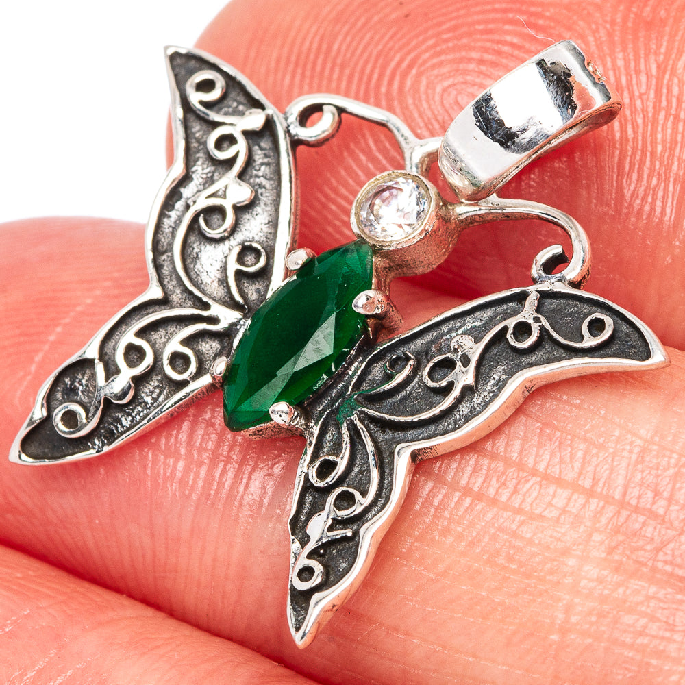 Silver butterfly pendant with green gemstone, small clear stone accents and loop bail.