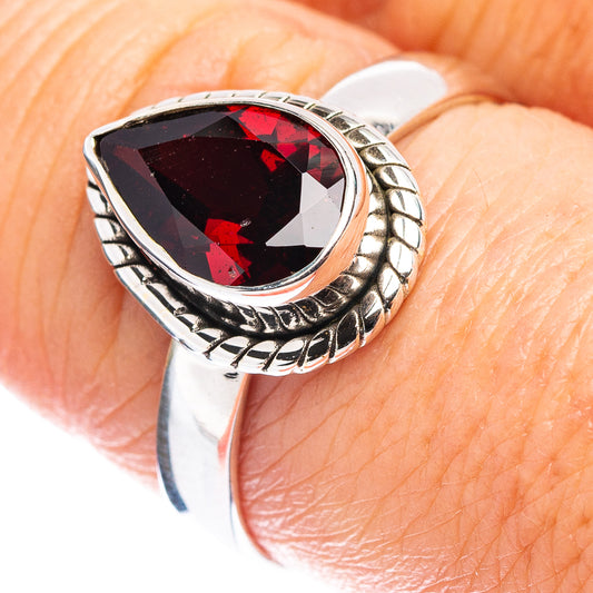 Sterling silver ring with oval faceted garnet gemstone and scalloped bezel setting